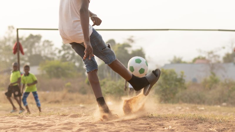 close-up-boy-running-after-ball